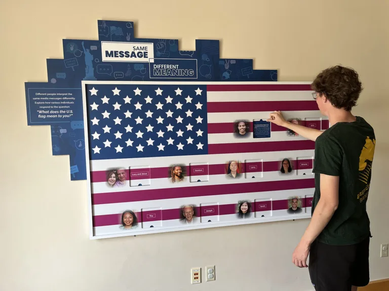 Student using Same Message Different Meaning flag activity at Wonder Media Exhibit